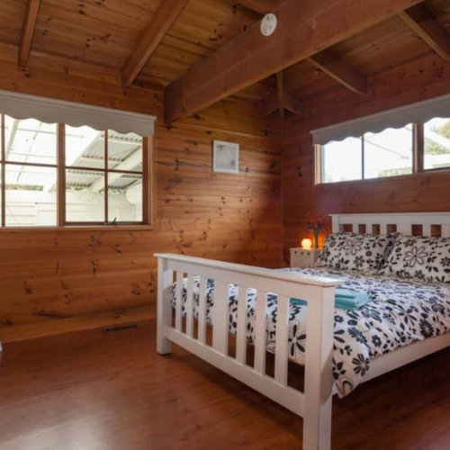 timber room with queen sized bed and white headboard