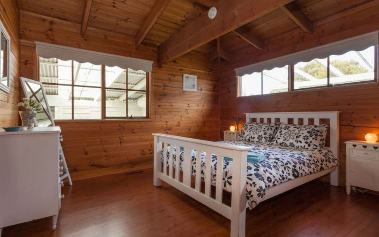 timber room with queen sized bed and white headboard