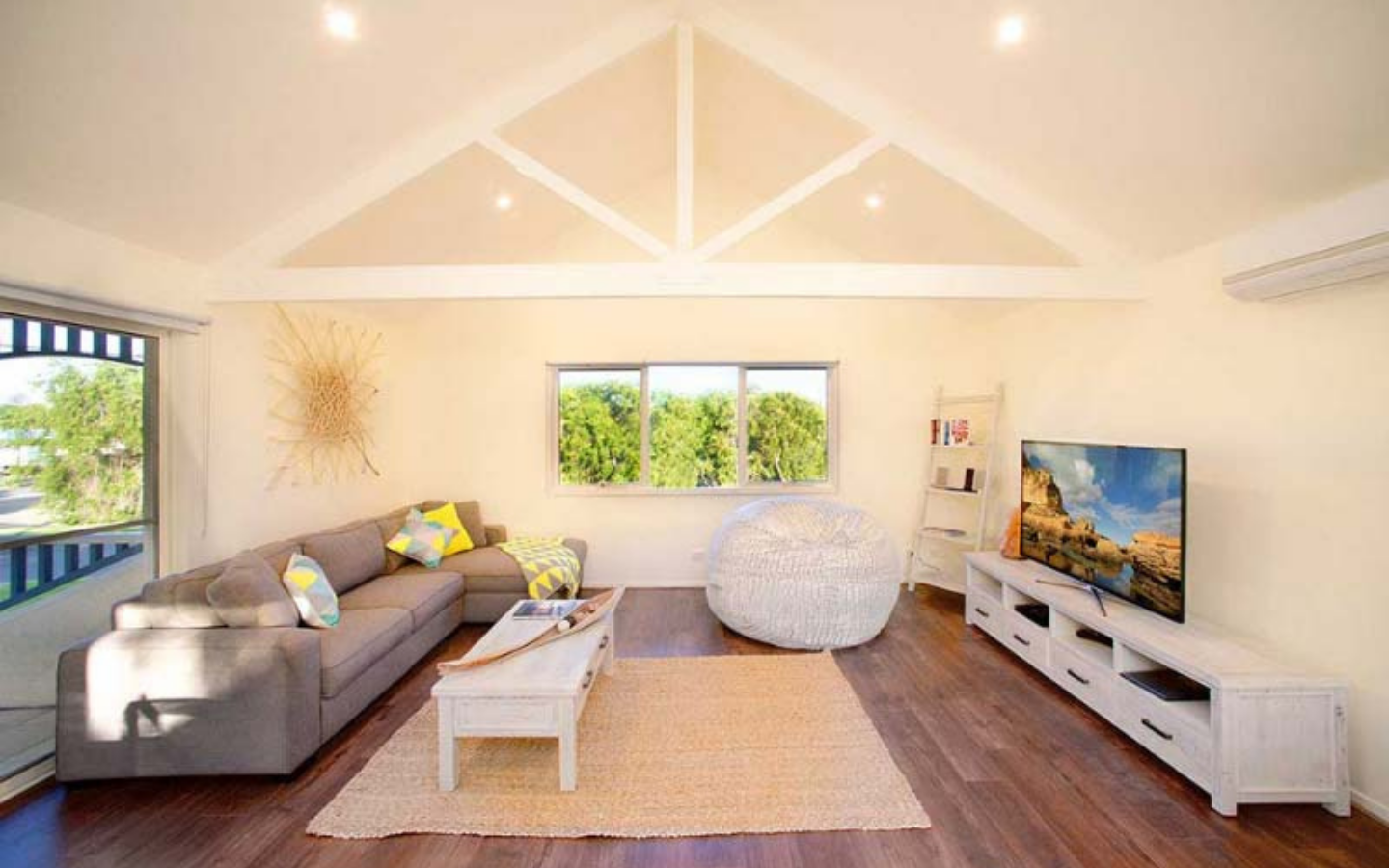 light filled living area with large sofa and television