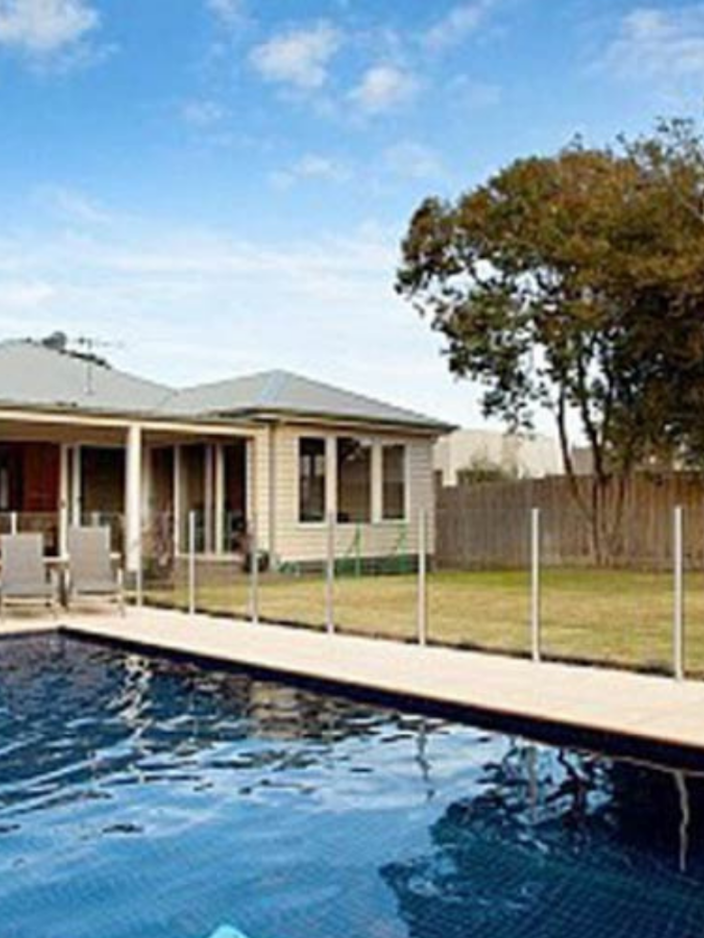 inground pool with holiday home in background