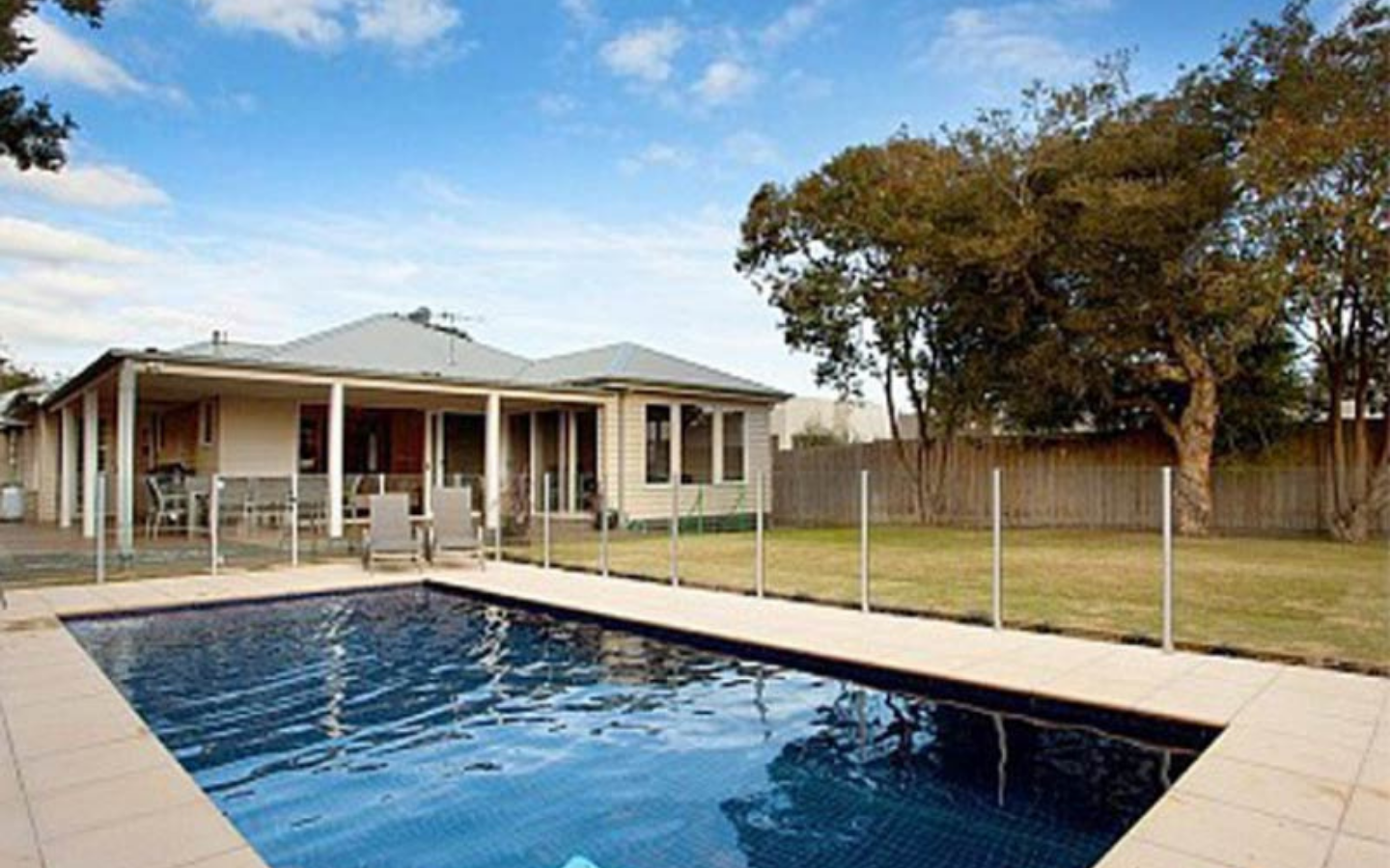 inground pool with holiday home in background