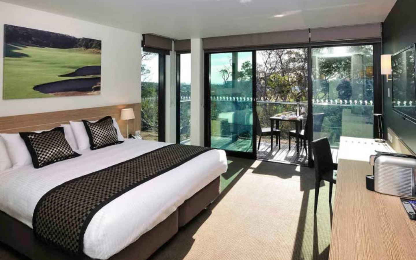 modern hotel room with bed and balcony with outdoor setting