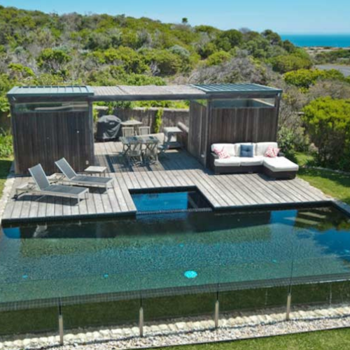 aerial view of spectacular beach house with infinity pool and deck set in teatree