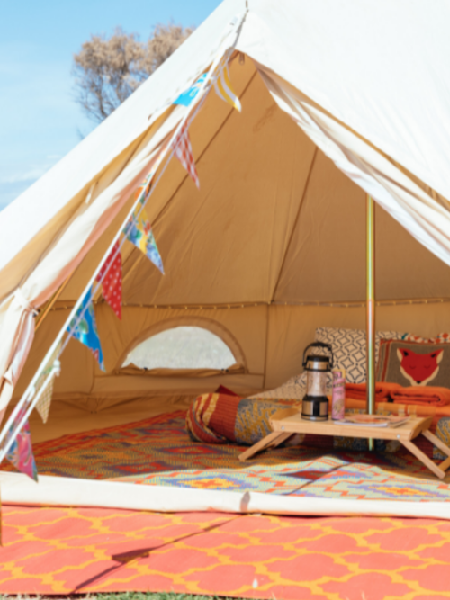 cream bell tent with colourful fit out