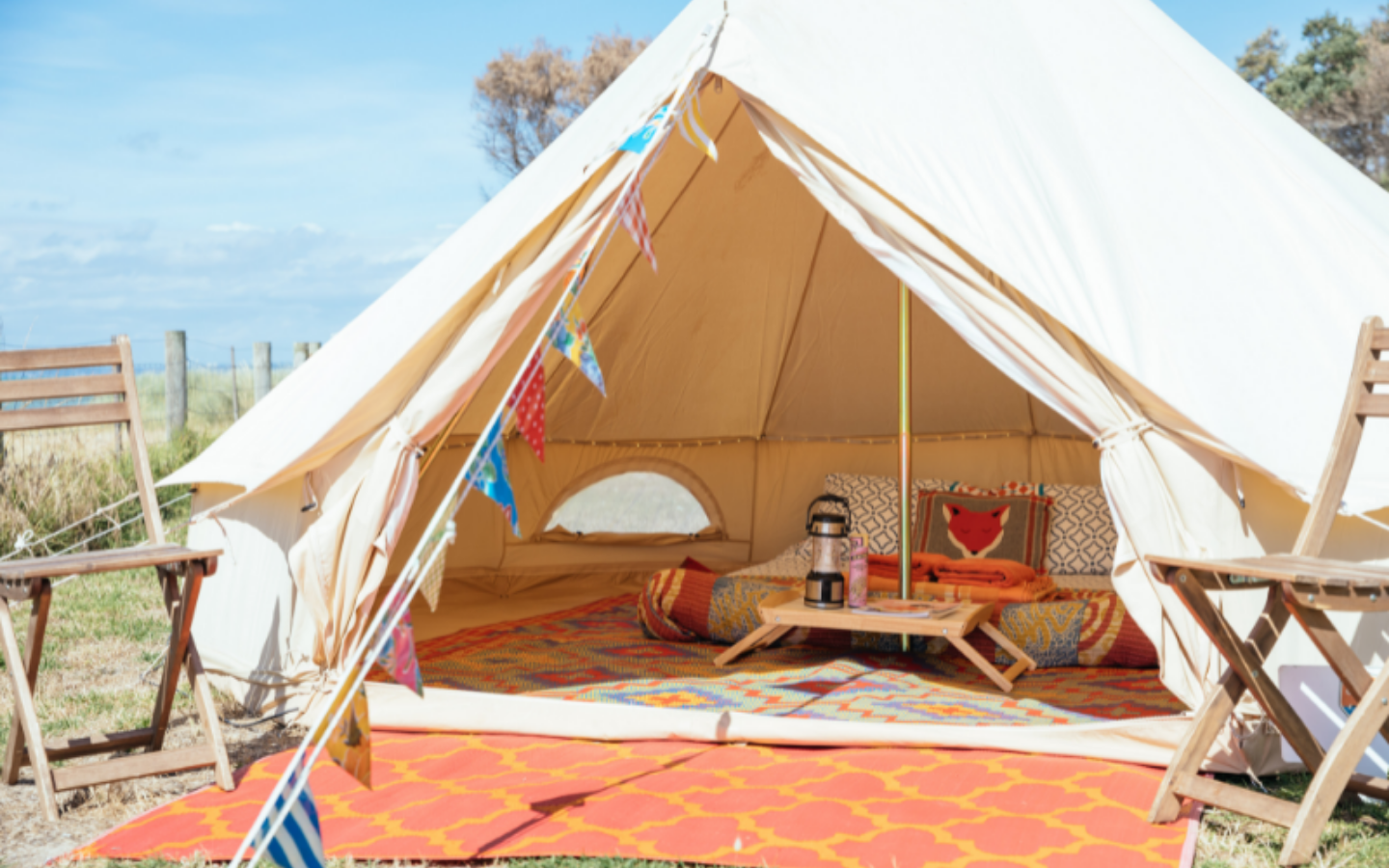 cream bell tent with colourful fit out