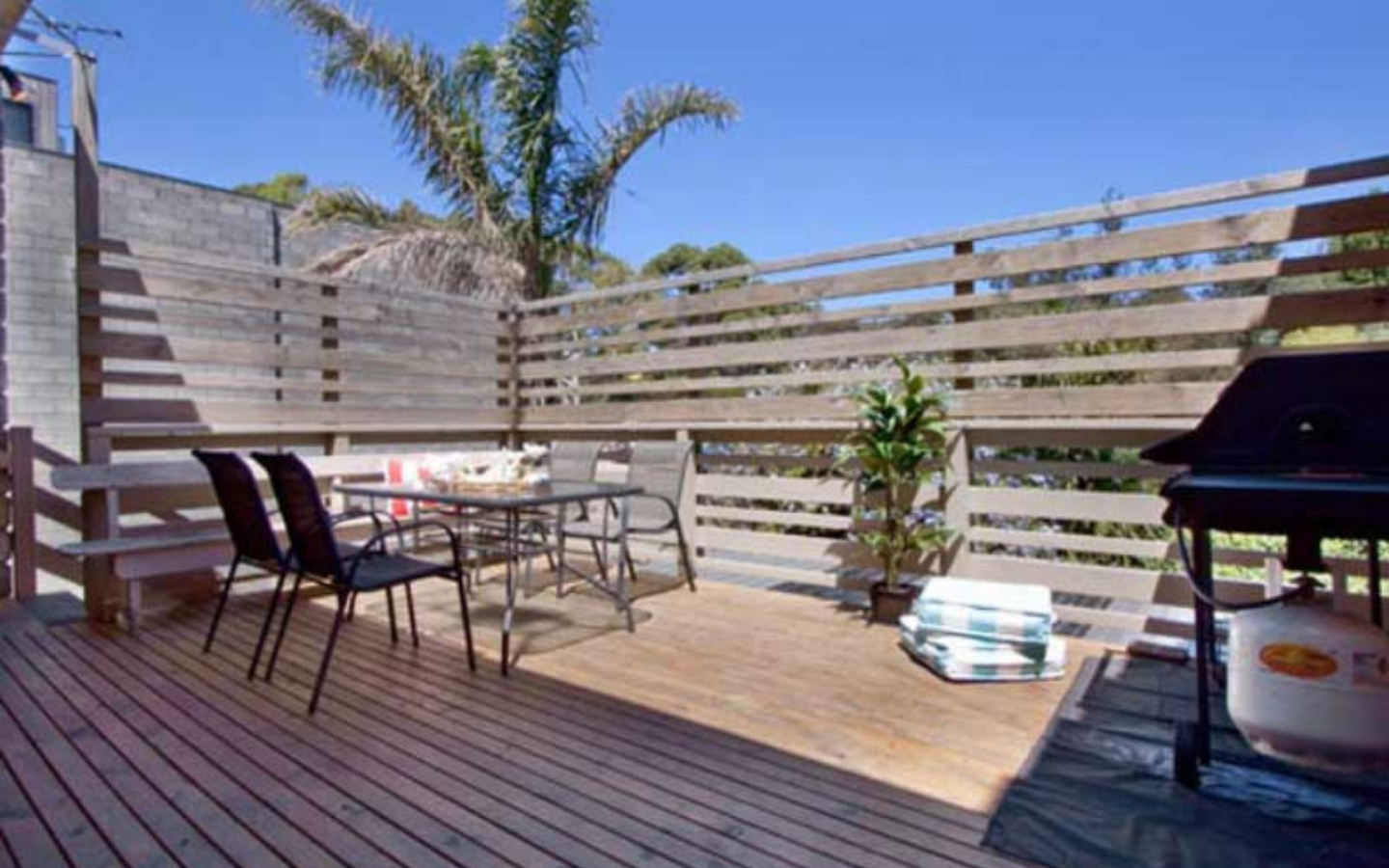 sunny deck with outdoor setting and barbeque