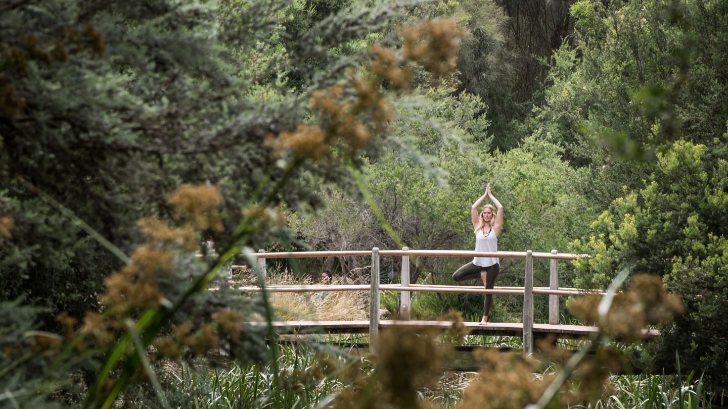 woman on bridge in tree yoga pose