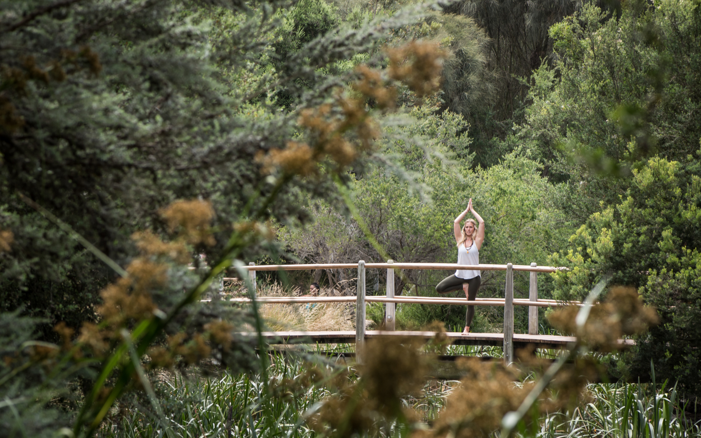woman on bridge in tree yoga pose