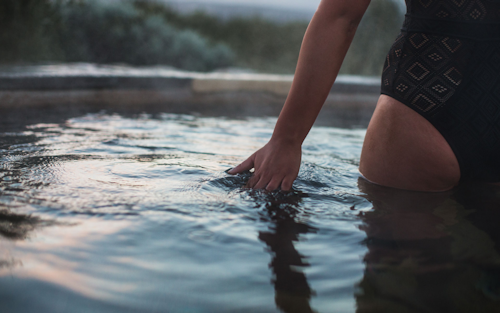 woman with hand floating through water