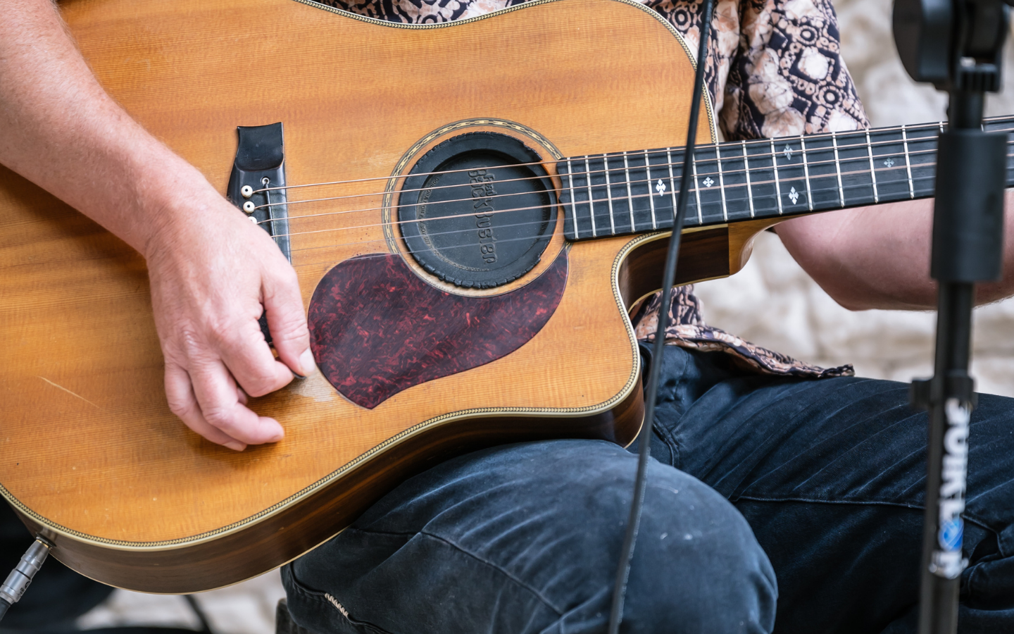 close up of man playing guitar on his lap