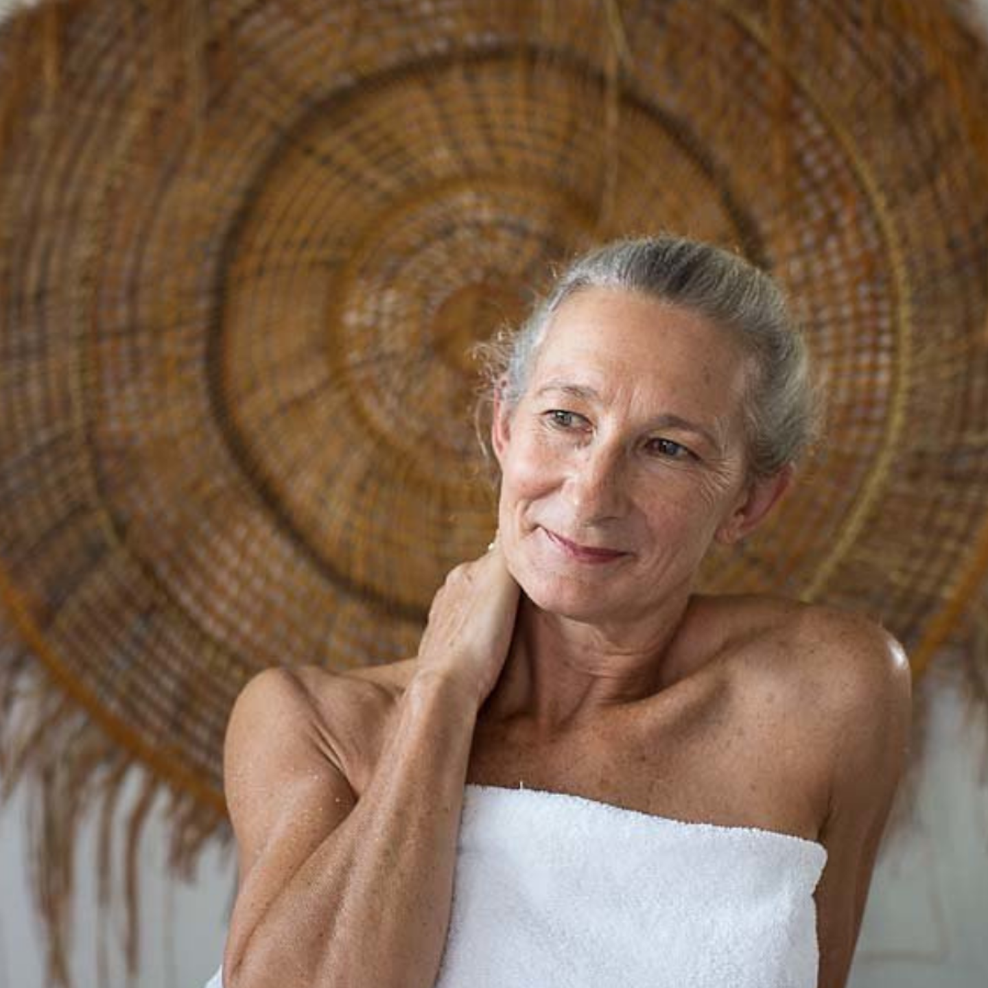 woman in towel with her hand on her neck after spa treatment