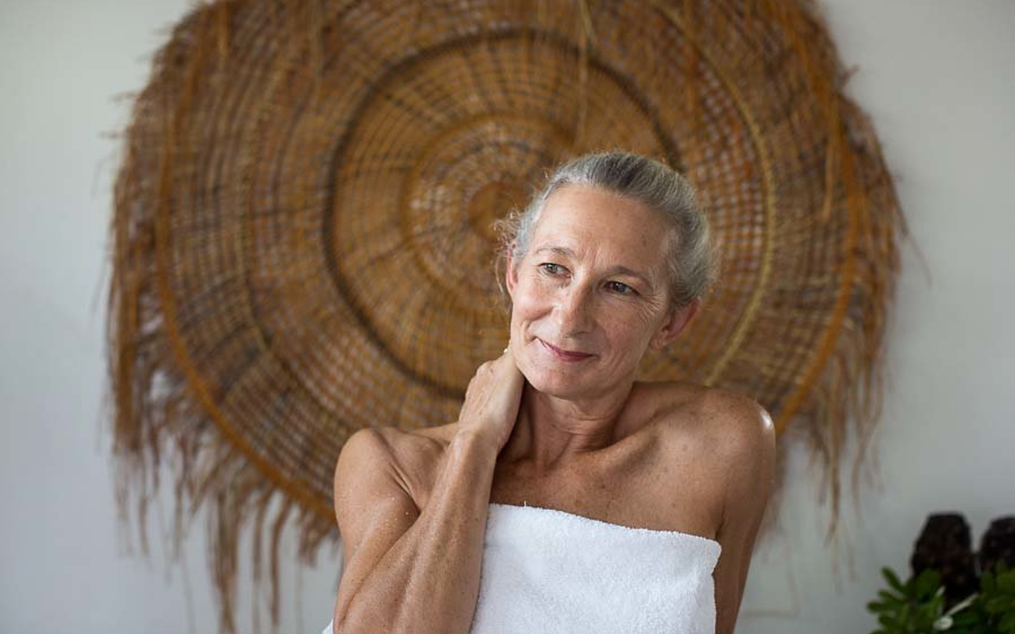 woman in towel with her hand on her neck after spa treatment