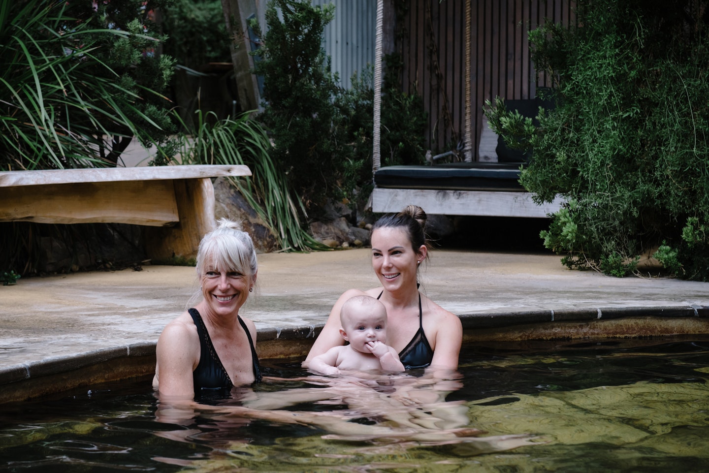 woman with her mum and her baby sitting in geothermal pool