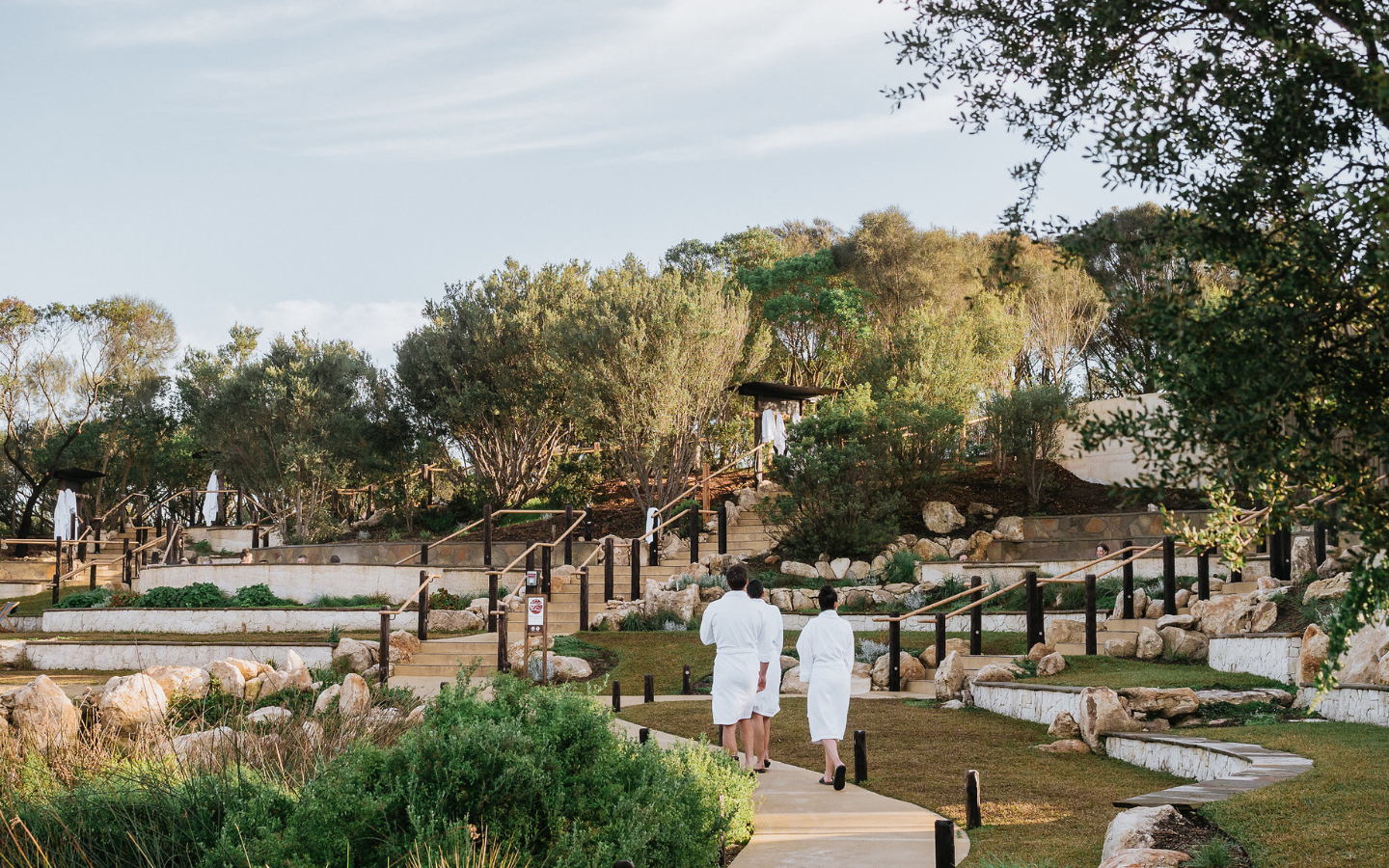 the back of guests walking down the amphitheatre pools path
