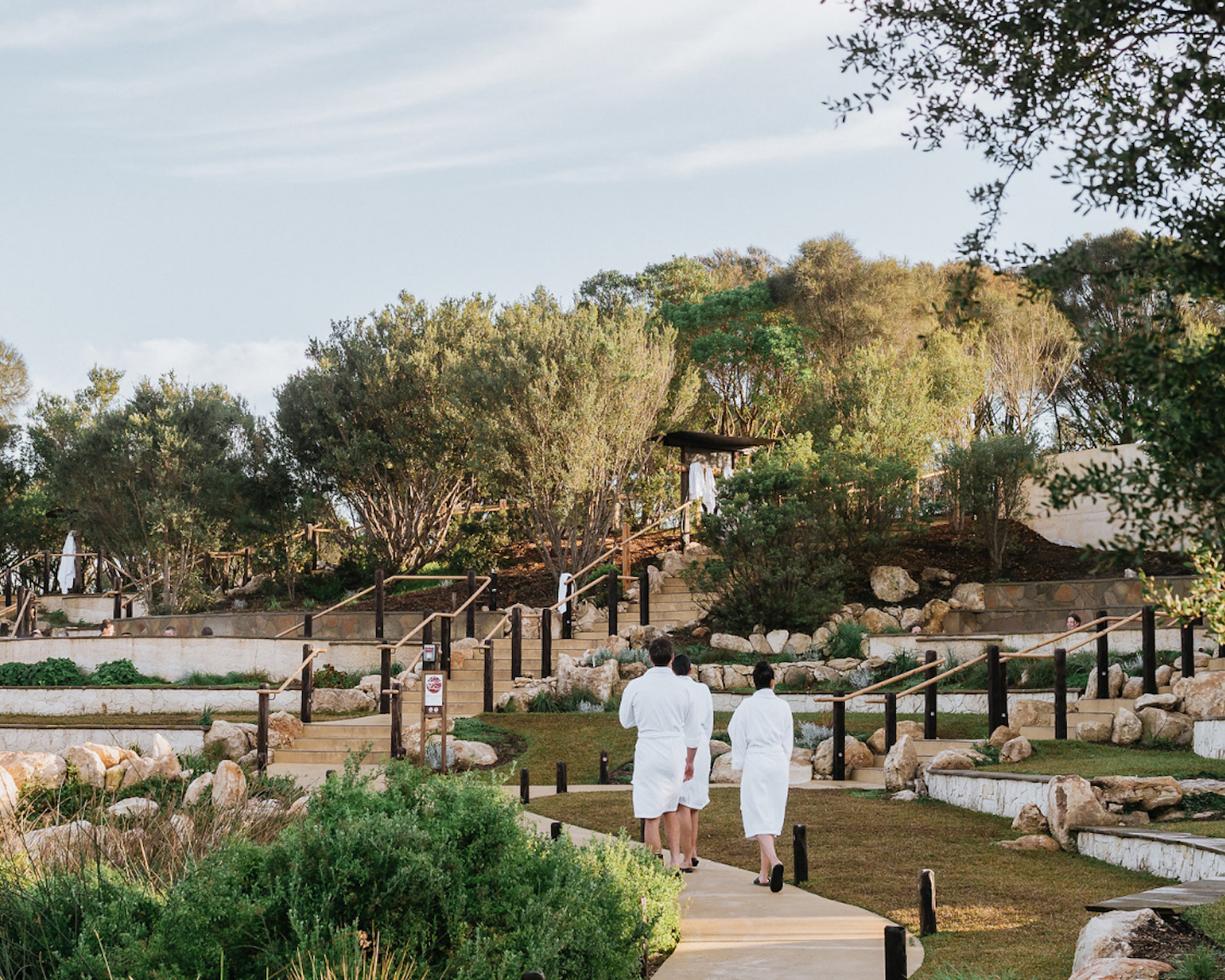 the back of guests walking down the amphitheatre pools path