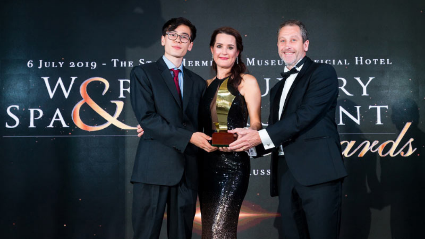 two men and a woman holding an award