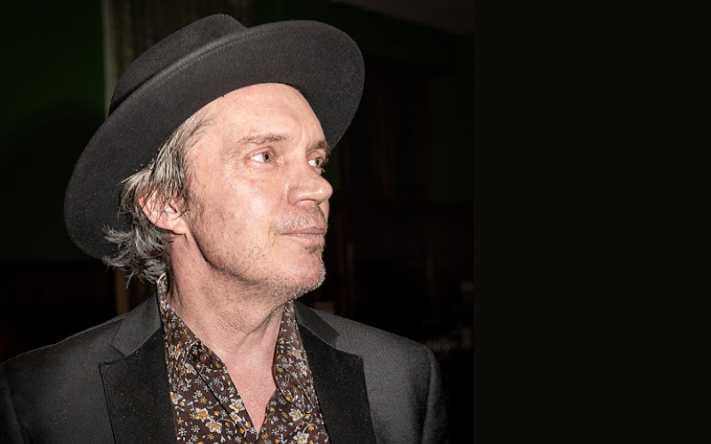 a man looking off the side from the camera with a hat on