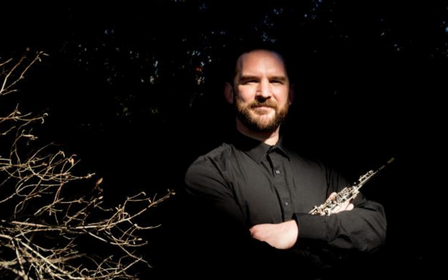 man looking into the camera holding a flute