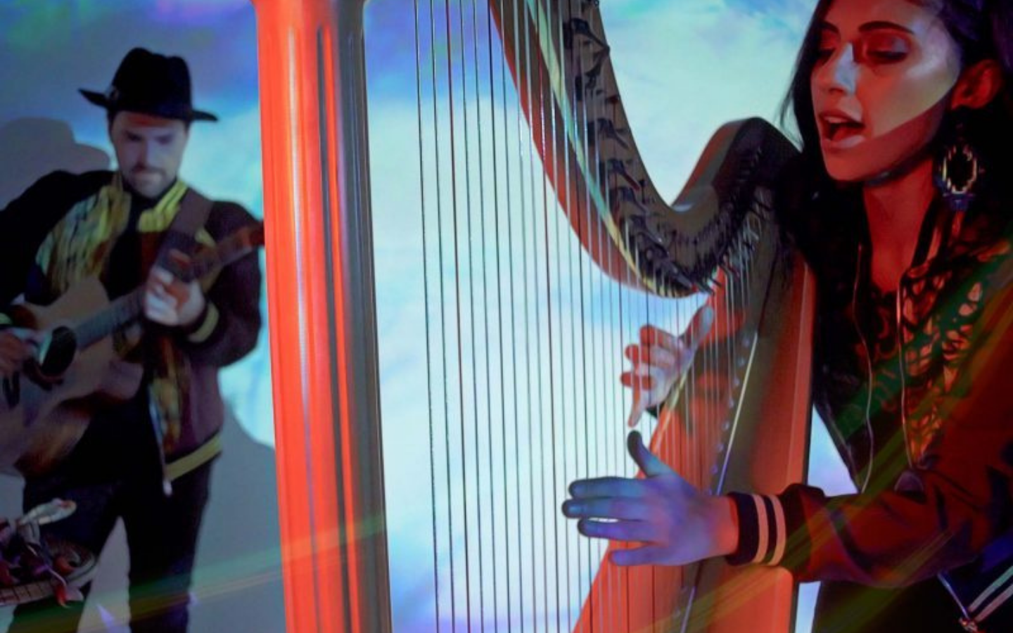 a man playing guitar and a woman playing the harp