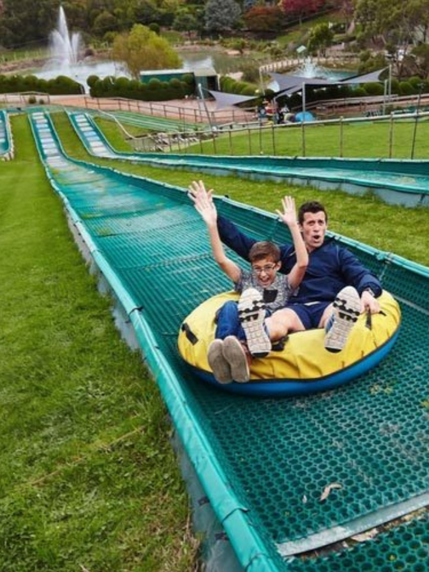 a father and son on a waterslide.