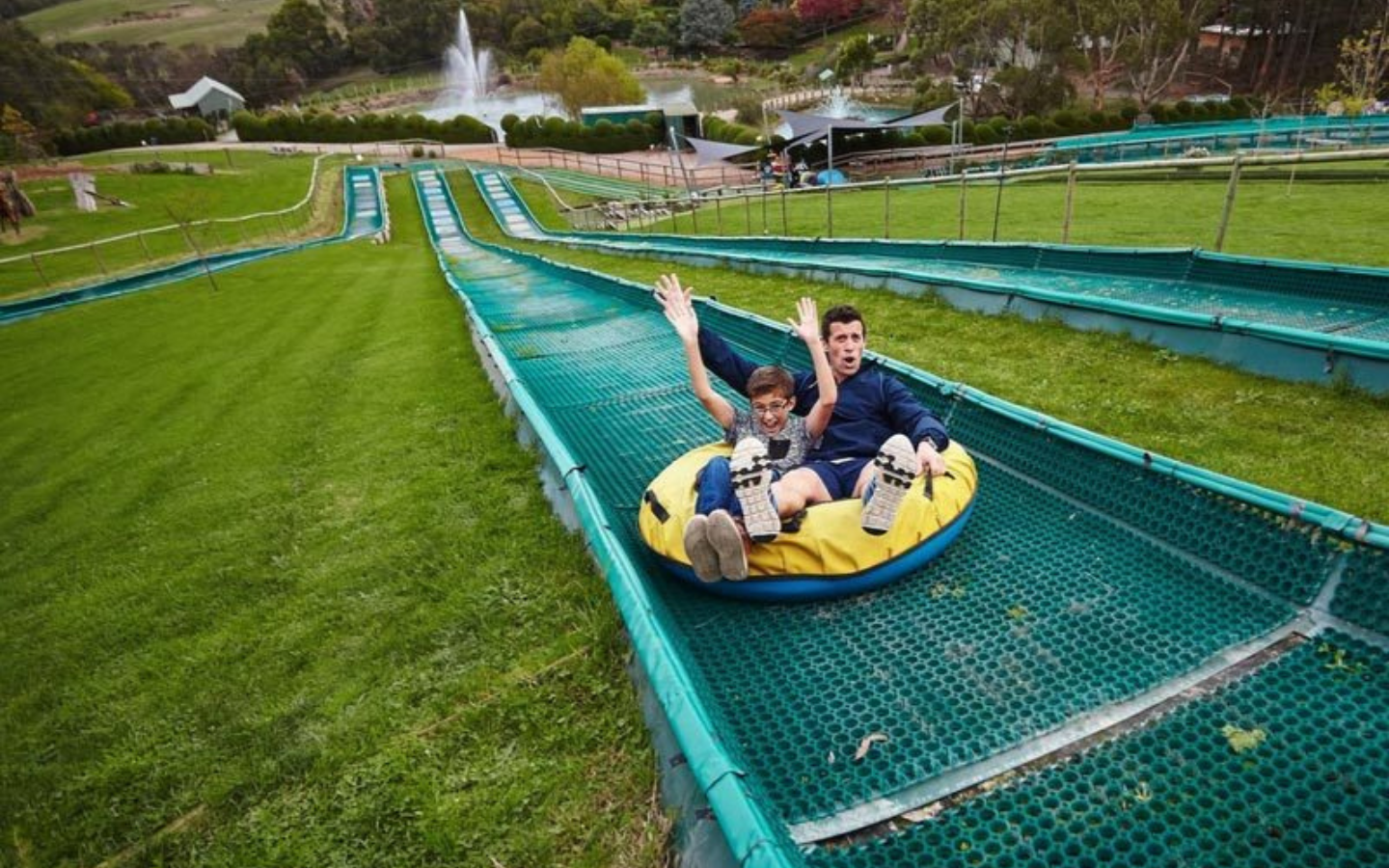 a father and son on a waterslide.