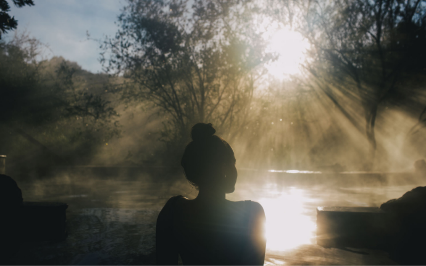 girl sitting in bath with sun shining and steam off pool