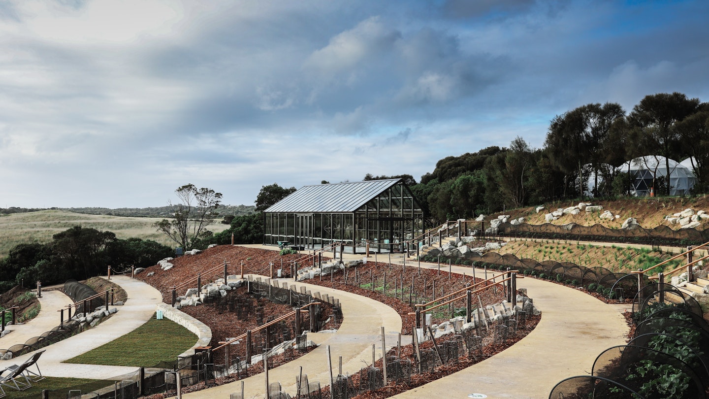 a three acre garden with glass house in the backdrop