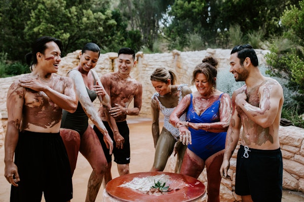 a group of people rubbing body clay on their bodies