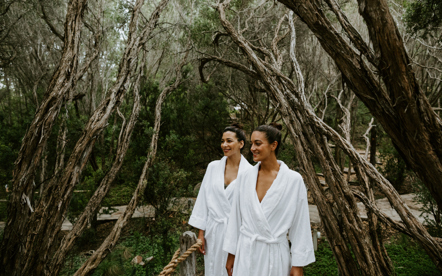 two girls walking amongst tress