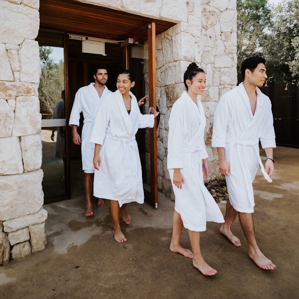 a group of people in robes walking out of a sauna