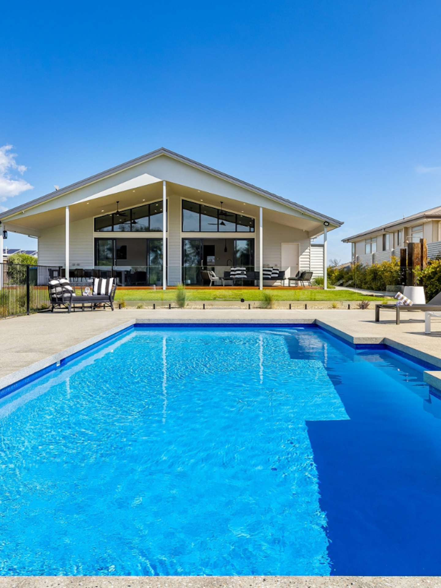 a large pool with a house in the background