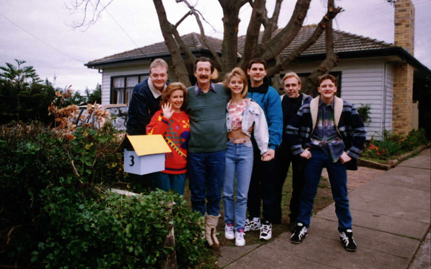 a group of people standing in front of a house