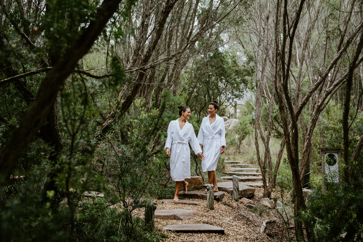 two girls walking through trees