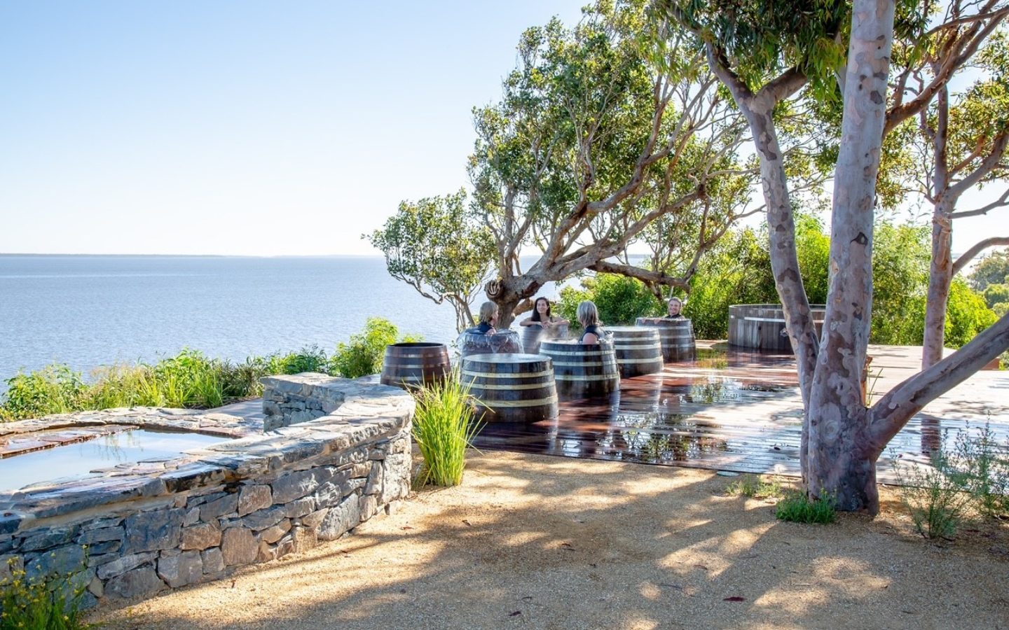 barrels of water with people in them overlooking a body of water