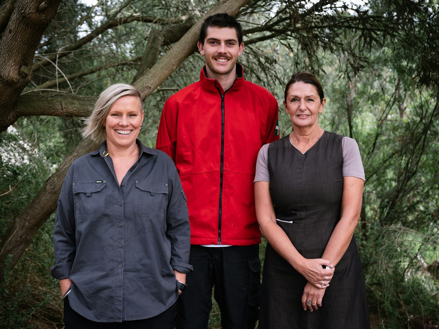 three people smiling to the camera