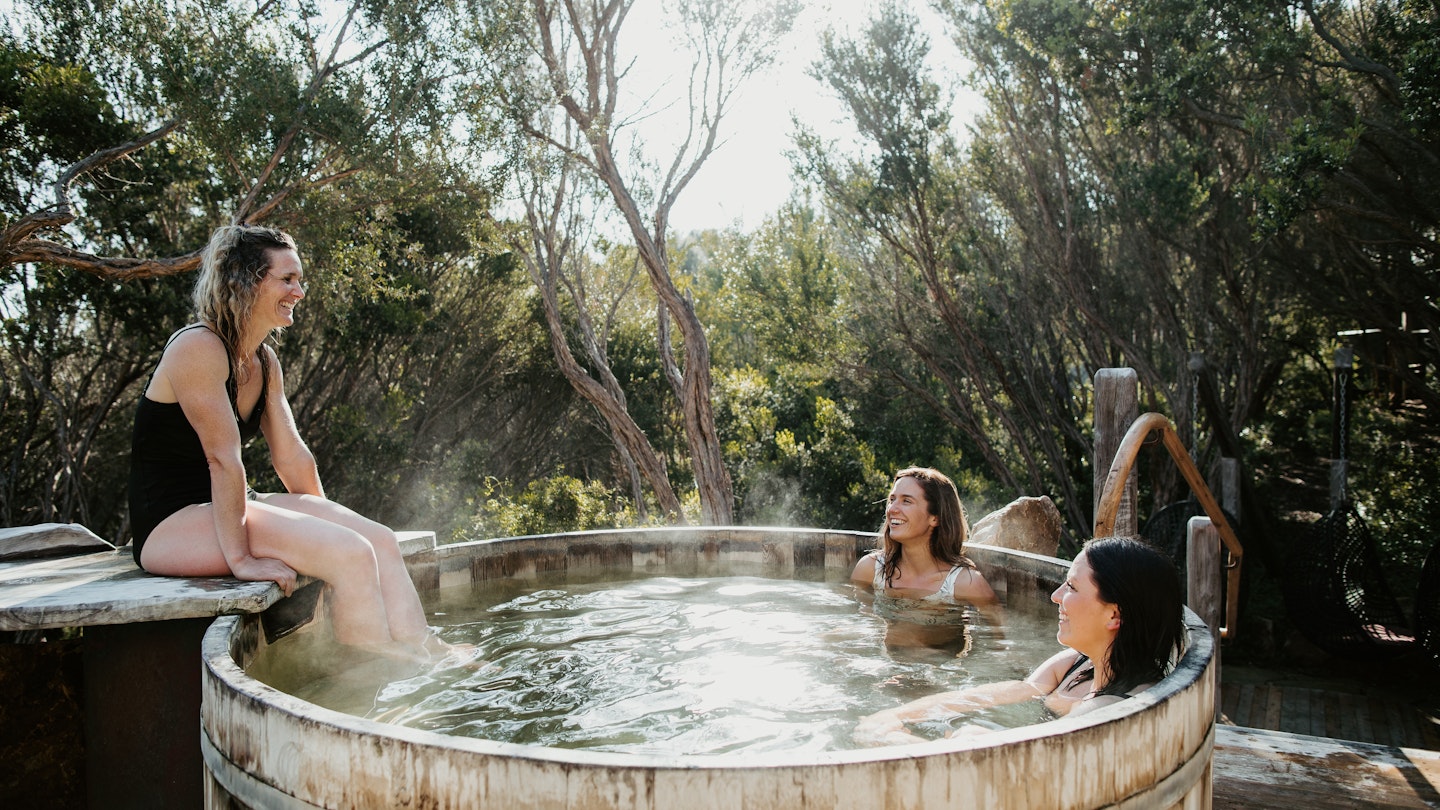 three women sitting in the barrel pool