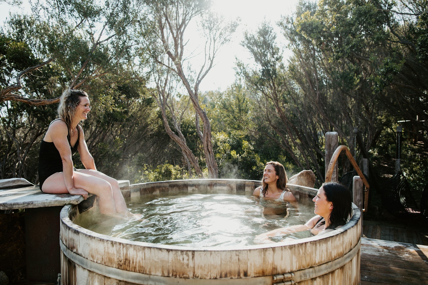 three women sitting in the barrel pool
