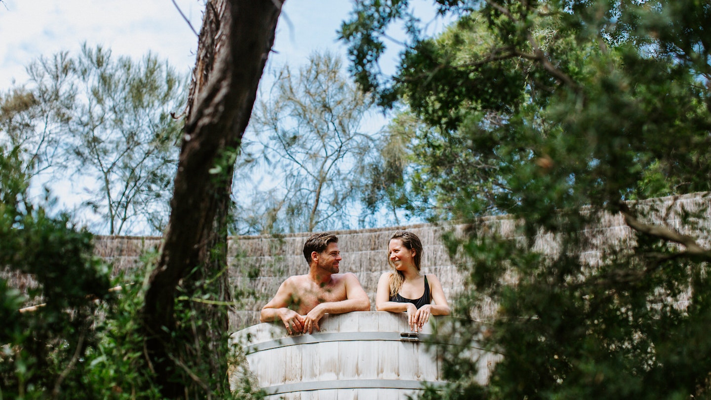 a couple sitting in a barrel pool