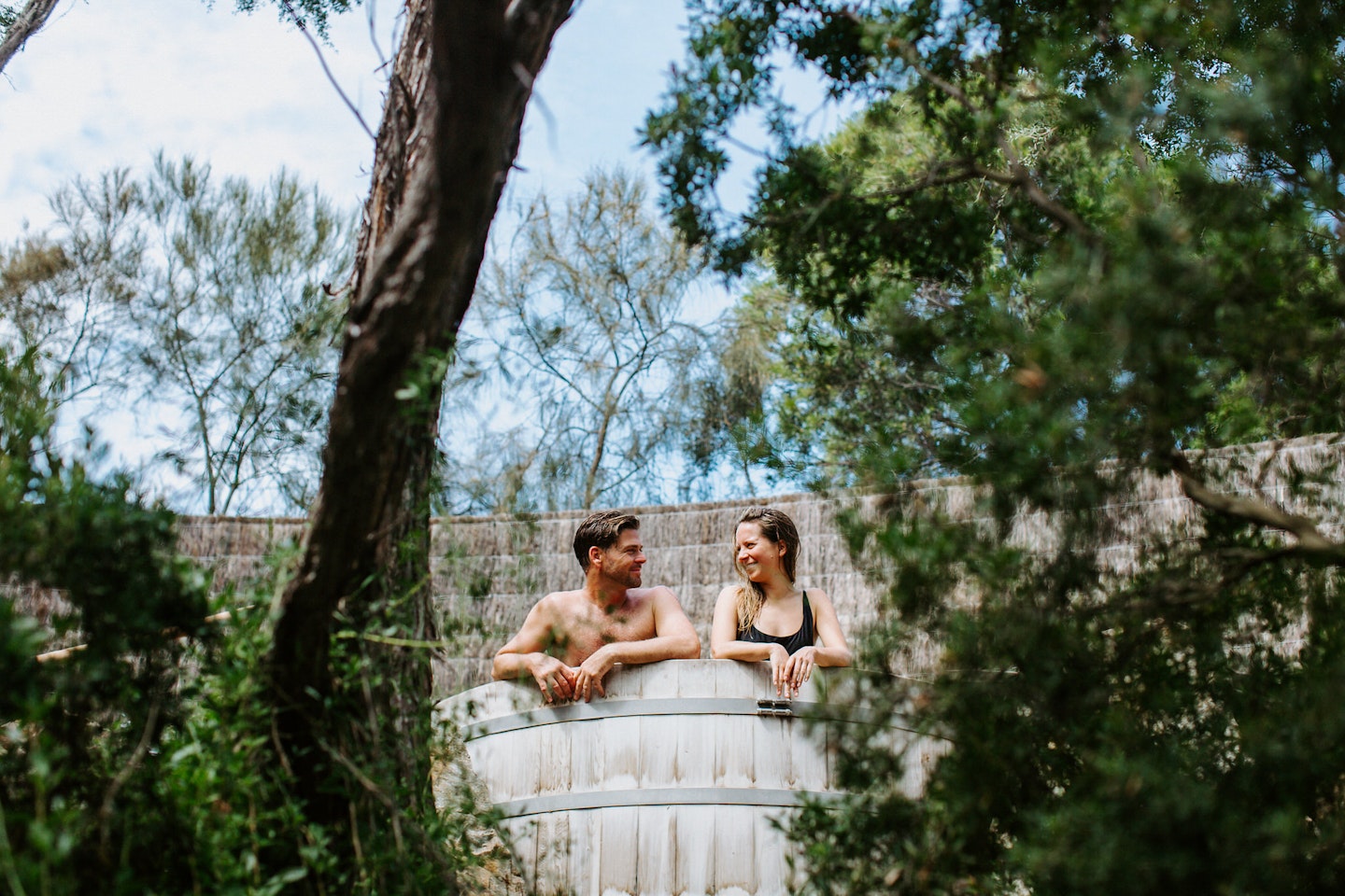a couple sitting in a barrel pool