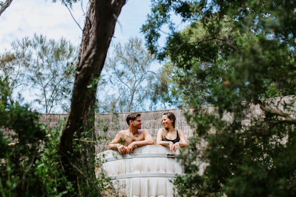 a couple sitting in a barrel pool