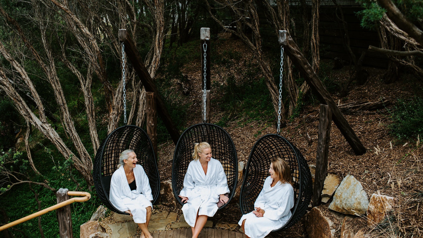 three women sitting in egg chairs