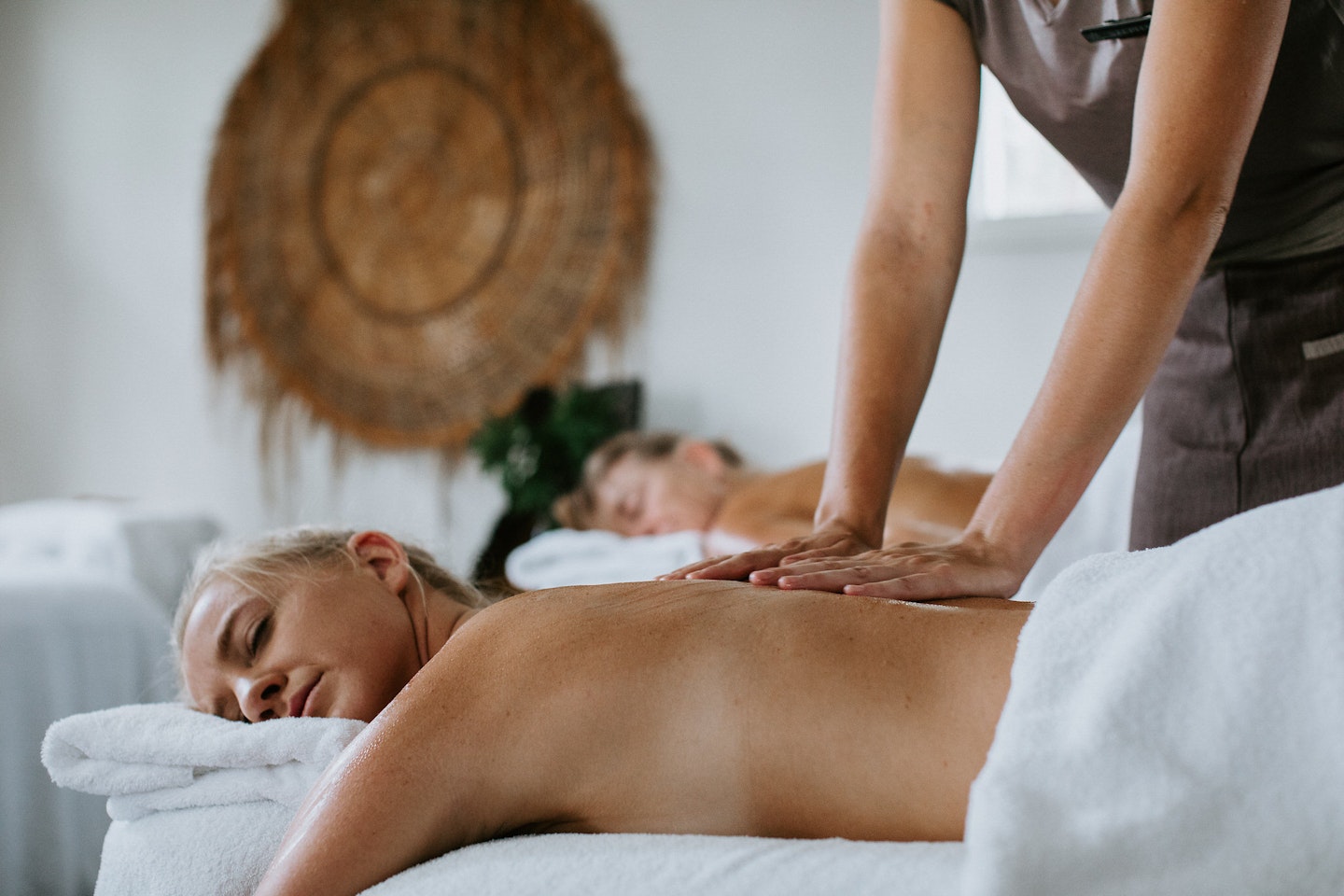 a women lying on a bed getting a back massage