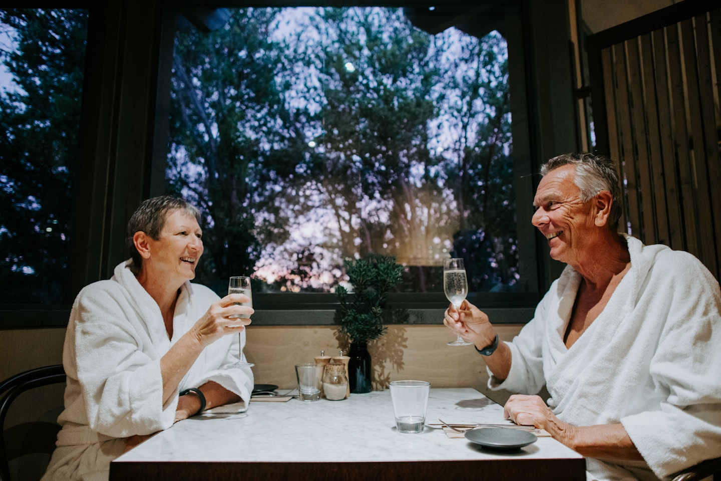an elderly couple dining in robes