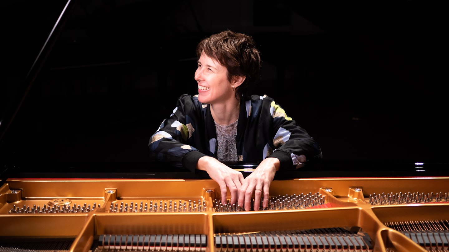 a woman standing over a piano