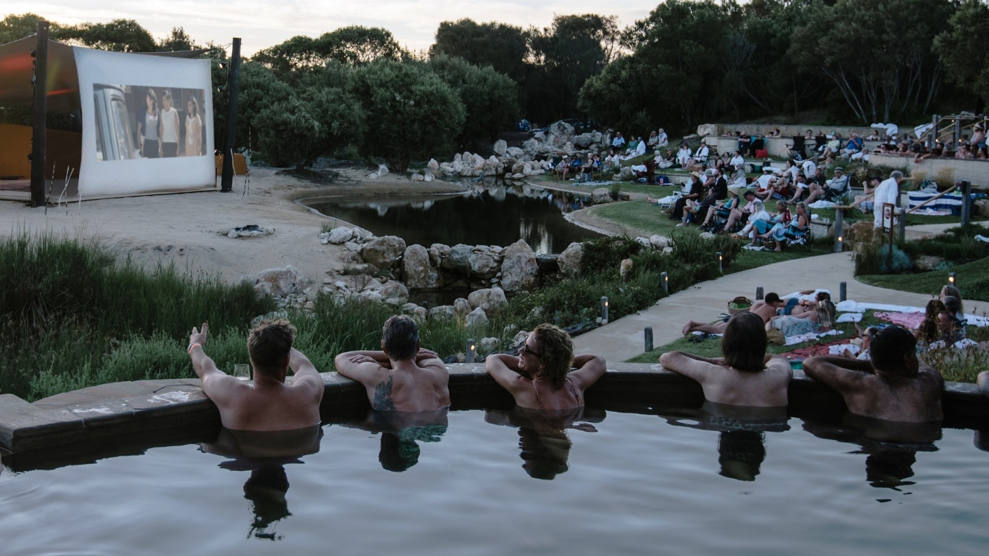 a group of people in a pool watching the cinema