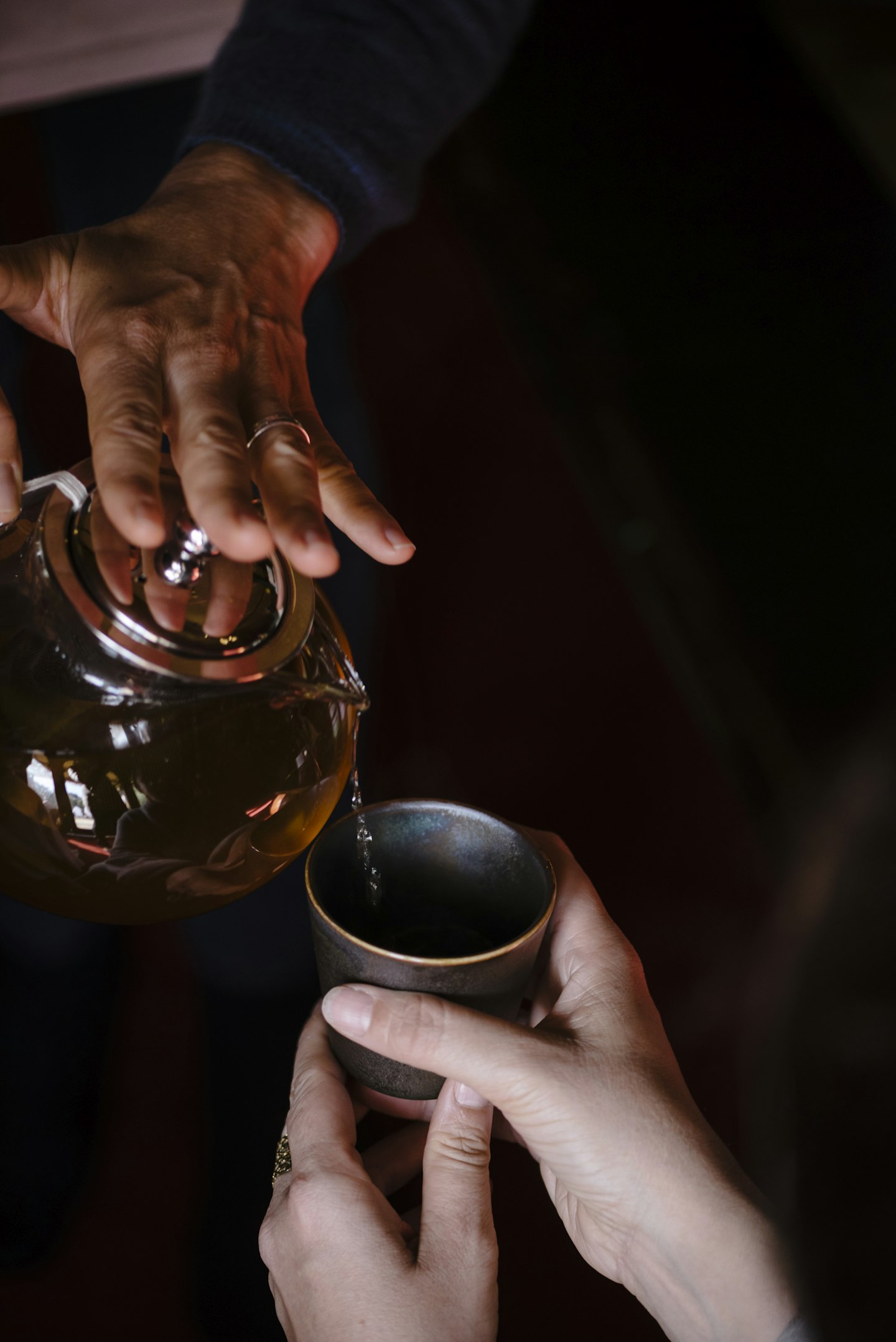 a pot of tea being poured into a ceramic cup
