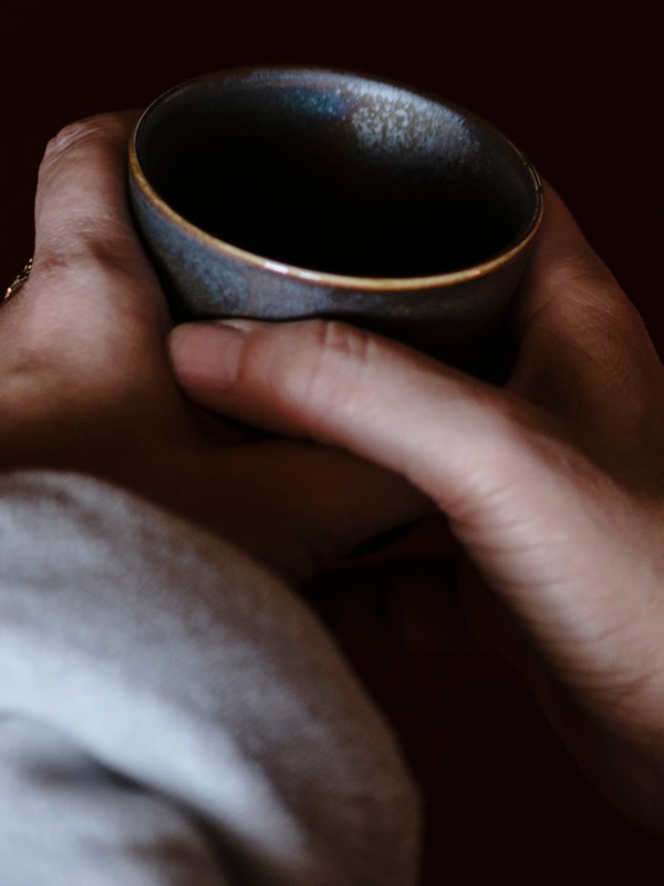 A woman in a robe holding a cup of tea