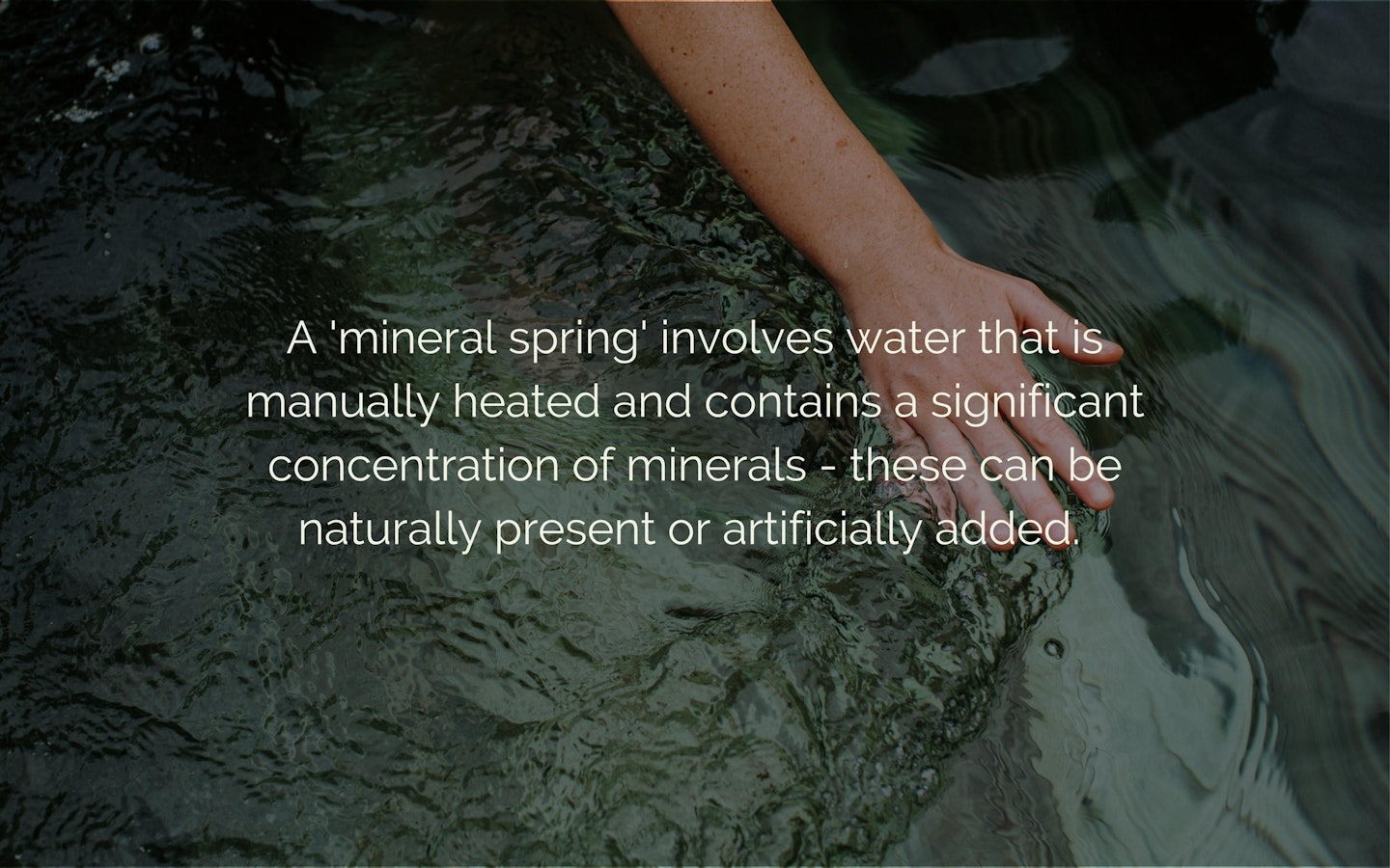 Text "A 'mineral spring' involves water that is manually heated and contains a significant concentration of minerals - these can be naturally present or artificially added" overlaying an image of water with a hand running through.