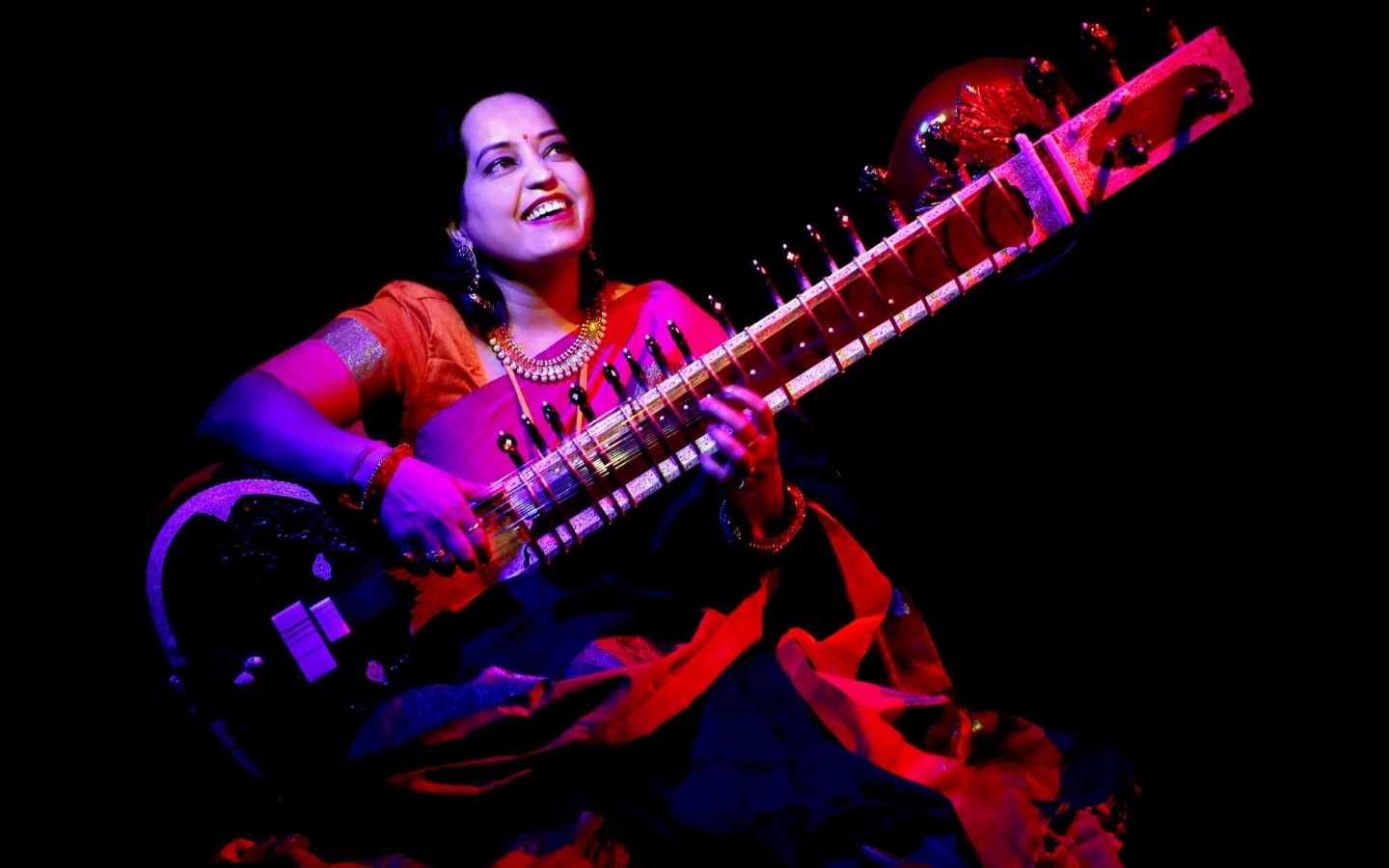 A woman playing a sitar