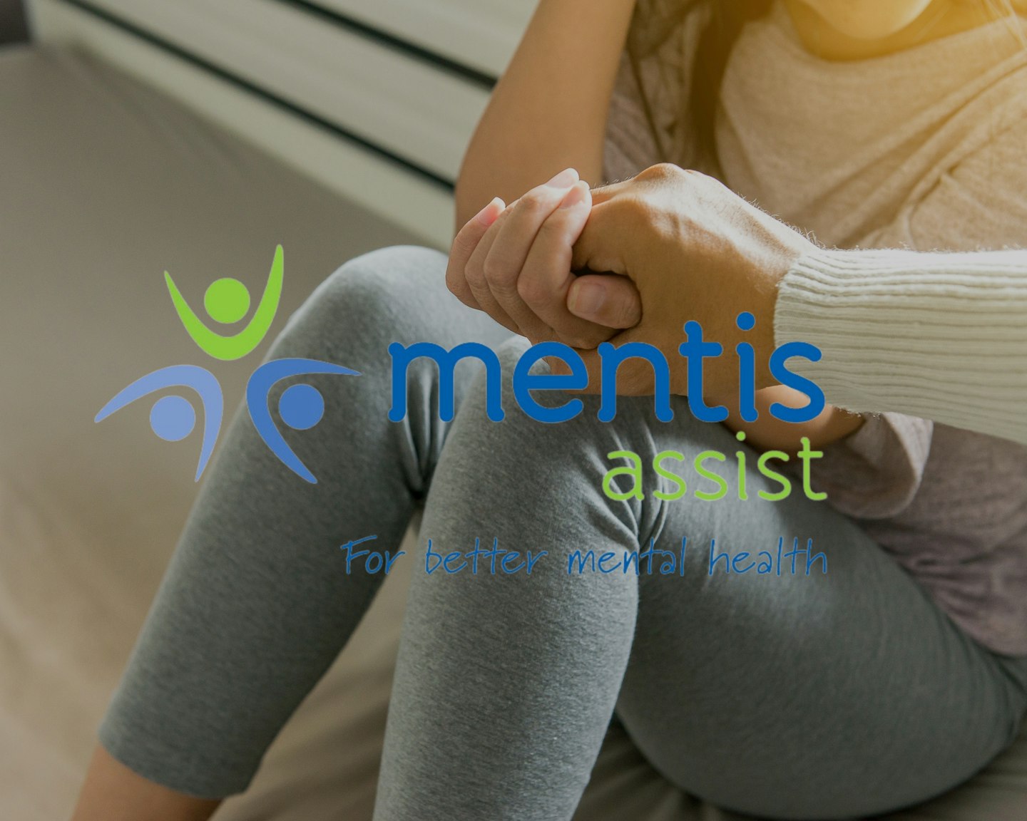 Text 'mentis assist' overlaying an image of a person holding a child's hand